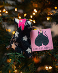 Stuffed animal toy with a pink label on a Christmas tree