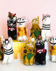 A collection of handcrafted felt cat decorations in various colors and patterns, each representing different artistic styles and characters.