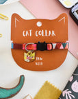 A colorful cat collar with abstract patterns displayed on a cat shaped card, featuring a breakaway safety clasp and named 'Paw Klee'.