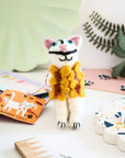 A collection of handcrafted felt cat decorations in various colors and patterns, each representing different artistic styles and characters.