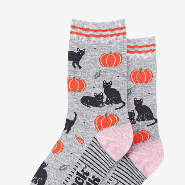 Two pairs of  Halloween socks with black cats and pumpkins on a grey background