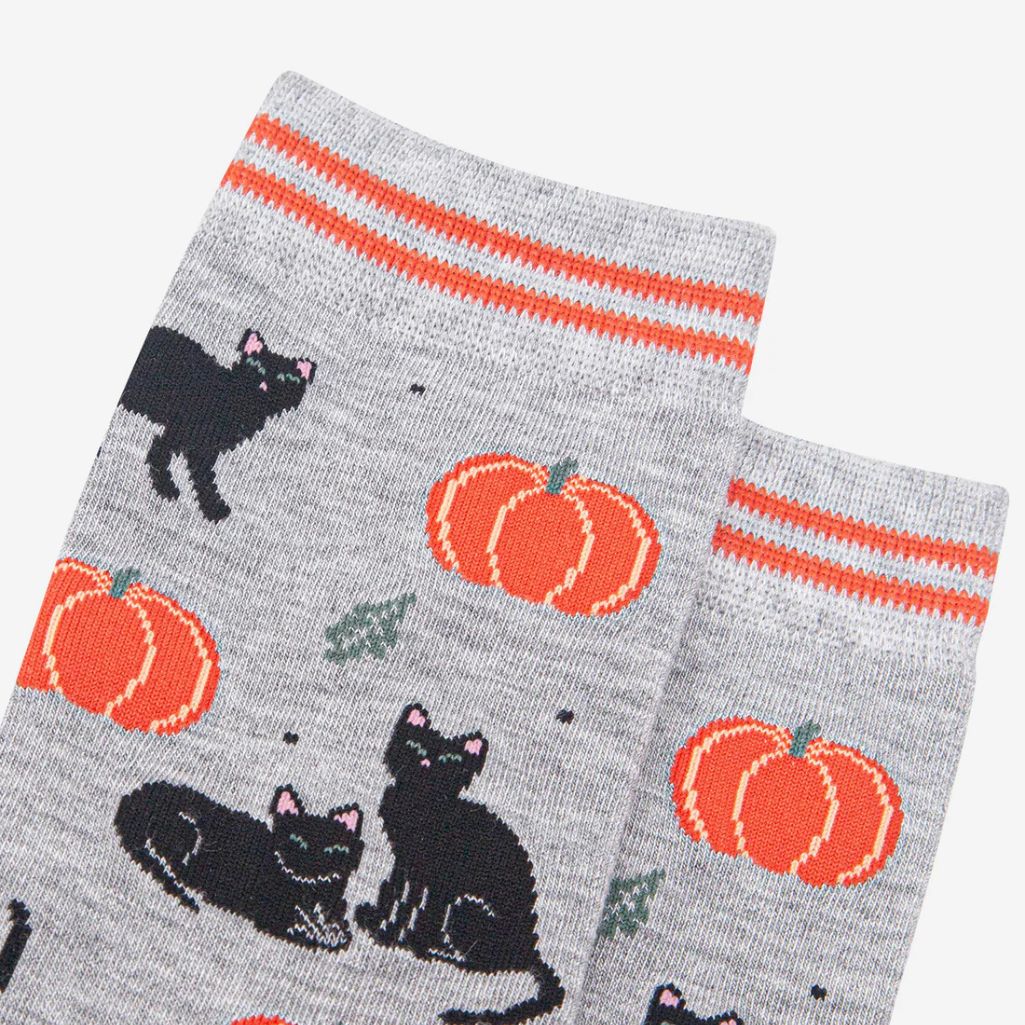 Halloween themed gray socks with orange pumpkins and black cats on a white background 