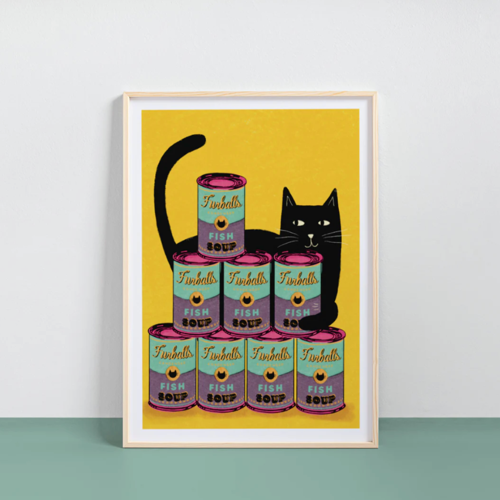 Framed artwork of a black cat surrounded by Tinnies fish soup cans on a yellow background.