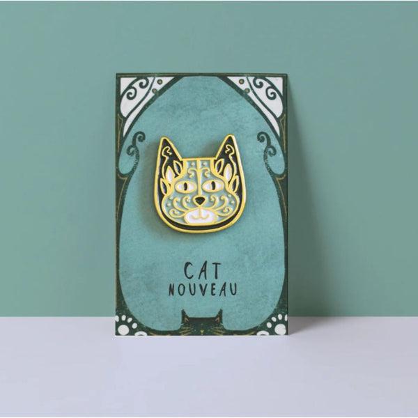 Card with a gold cat-shaped brooch on a teal background