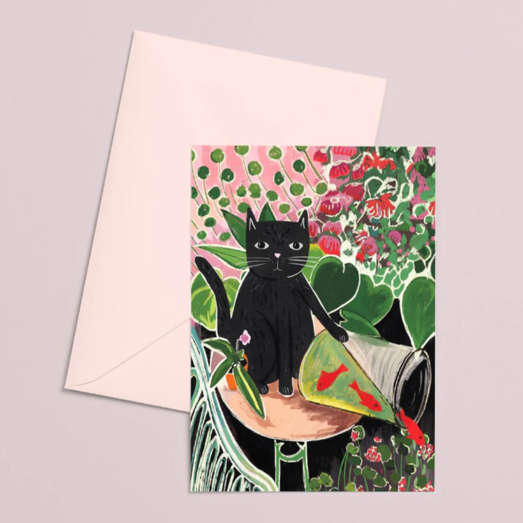 Greeting card with a black cat illustration on a floral background, accompanied by a matching envelope.