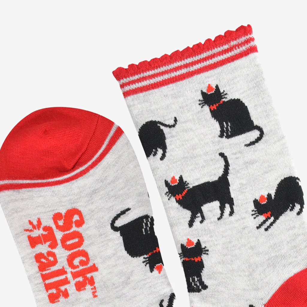 Two socks with black dog illustrations and red accents on a white background