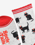 Two socks with black dog illustrations and red accents on a white background