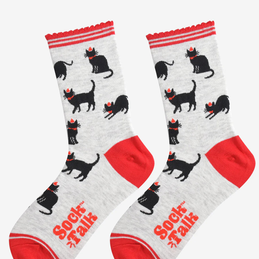 Pair of socks with festive black cat pattern and red accents on a white background