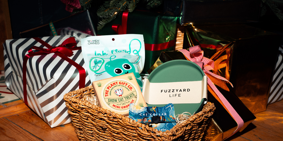 cat toys and gifts in a hamper with christmas presents in the background