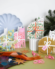 Decorative gift cards with festive cat designs on a table with Christmas decorations.