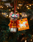Cat-shaped ornament with an orange tag on a Christmas tree