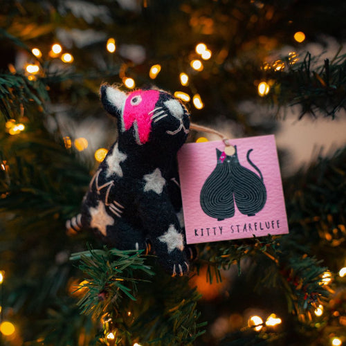 Stuffed animal toy with a pink label on a Christmas tree