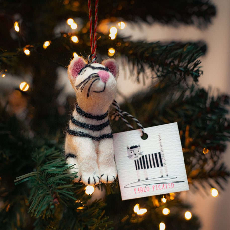 cat shaped christmas decoration placed in a fir tree