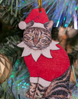 Cat Christmas ornament wearing a Santa hat and red outfit on a decorated tree.