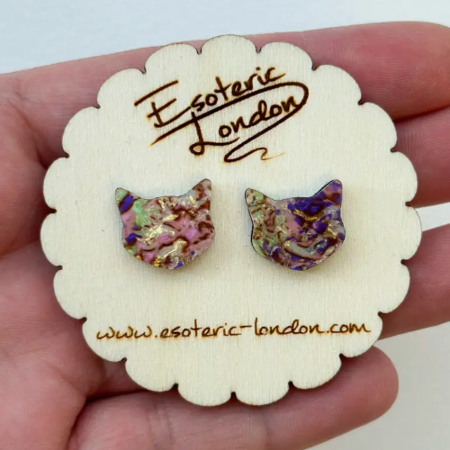 Cat-shaped earrings on a 'Esoteric London' branded card held in a hand.