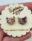 Cat-shaped earrings on a 'Esoteric London' branded card held in a hand.