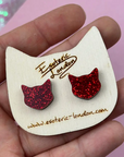 Red glitter cat ear-shaped earrings on a white card with 'Esoteric London' branding.