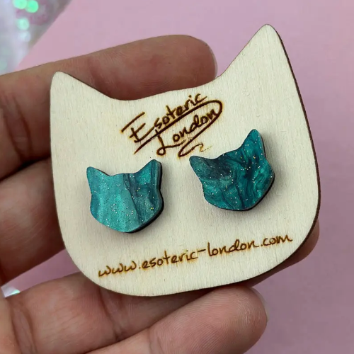 Blue cat-shaped earrings on a wooden display card with &#39;Esoteric London&#39; branding.